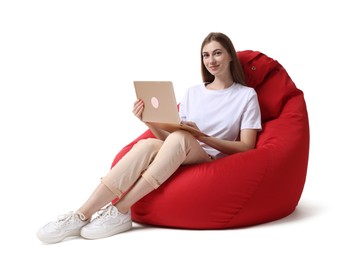 Photo of Beautiful young woman with laptop sitting on red bean bag chair against white background