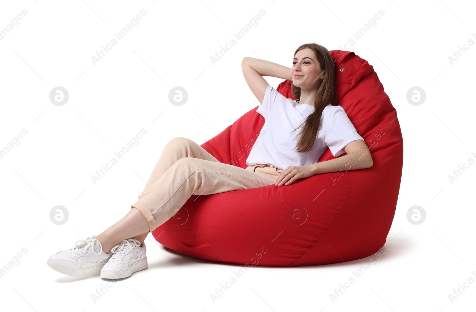 Photo of Beautiful young woman sitting on red bean bag chair against white background