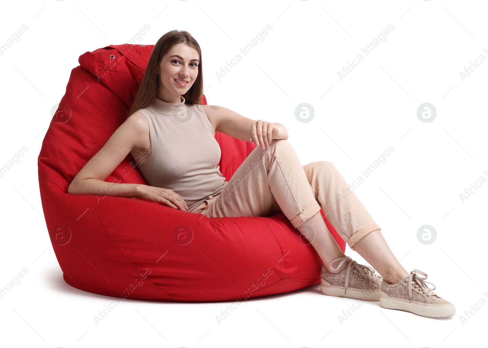 Photo of Smiling woman sitting on red bean bag chair against white background