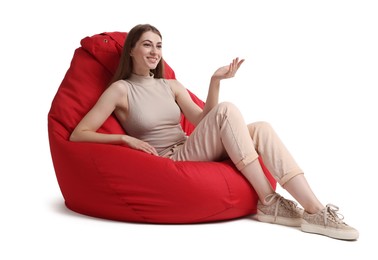 Photo of Smiling woman sitting on red bean bag chair against white background