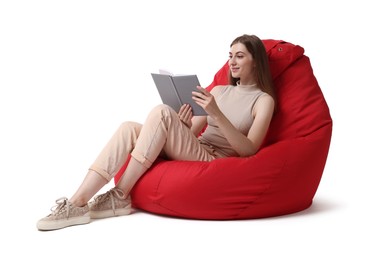 Photo of Beautiful young woman reading book on red bean bag chair against white background