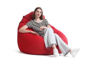 Photo of Beautiful young woman sitting on red bean bag chair against white background