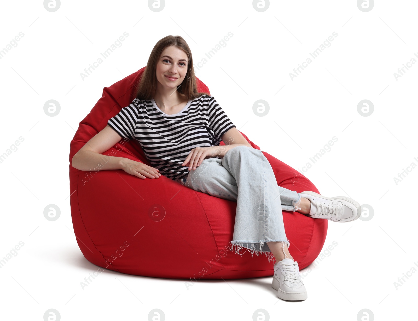 Photo of Beautiful young woman sitting on red bean bag chair against white background