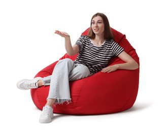 Photo of Beautiful young woman sitting on red bean bag chair against white background