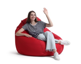 Photo of Smiling woman sitting on red bean bag chair against white background