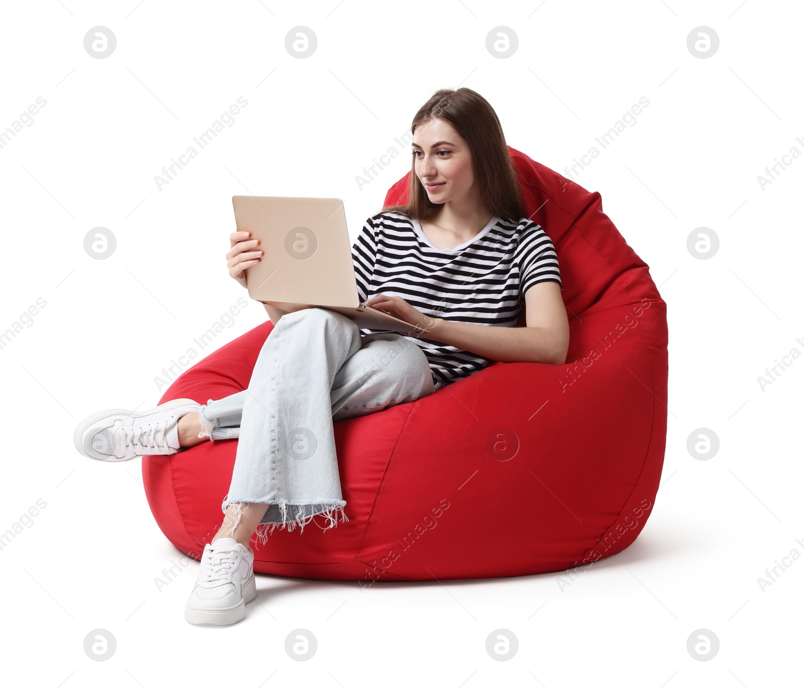 Photo of Beautiful young woman with laptop sitting on red bean bag chair against white background