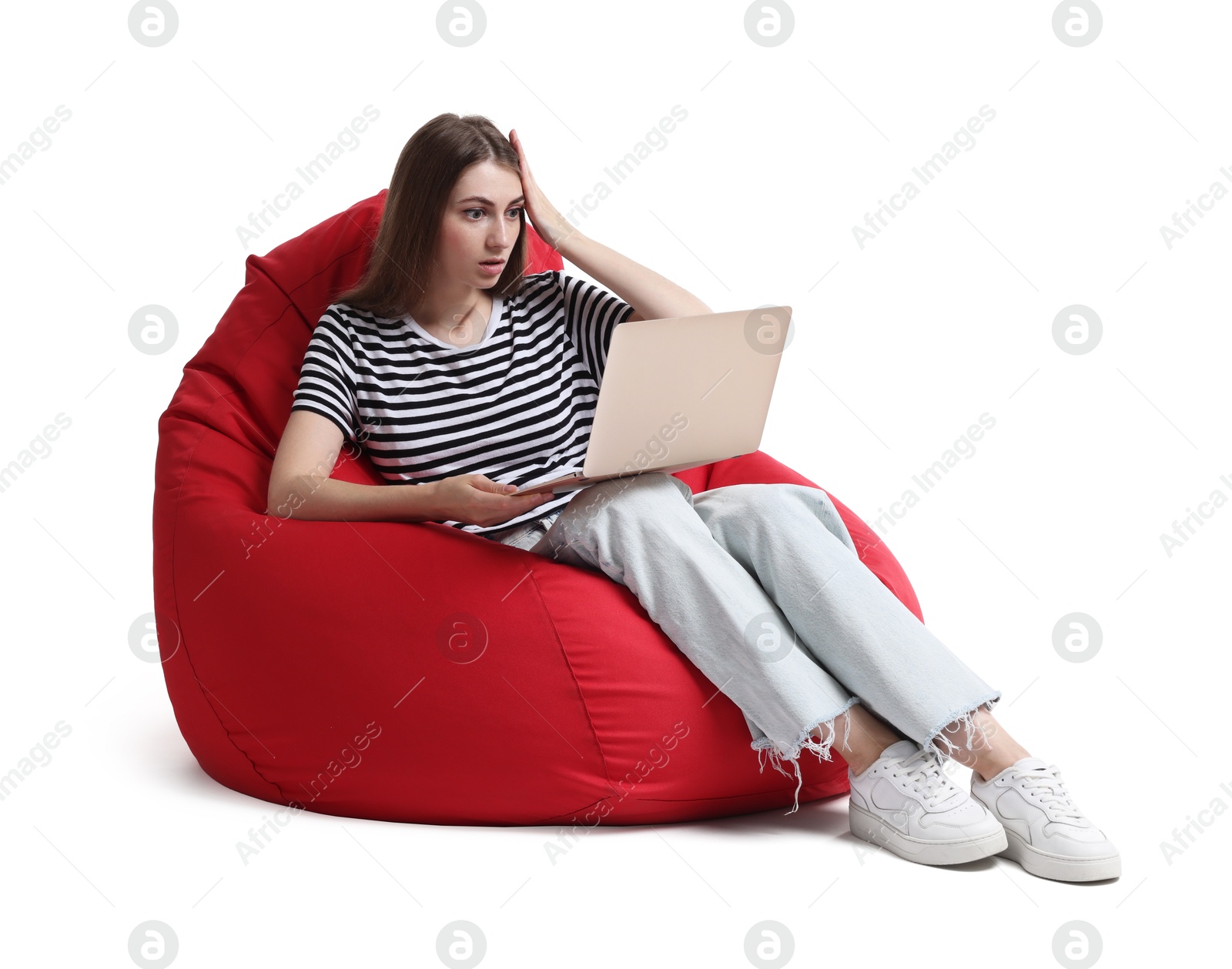 Photo of Emotional woman with laptop having online meeting while sitting on red bean bag chair against white background