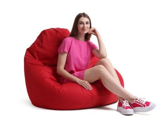 Photo of Beautiful young woman sitting on red bean bag chair against white background