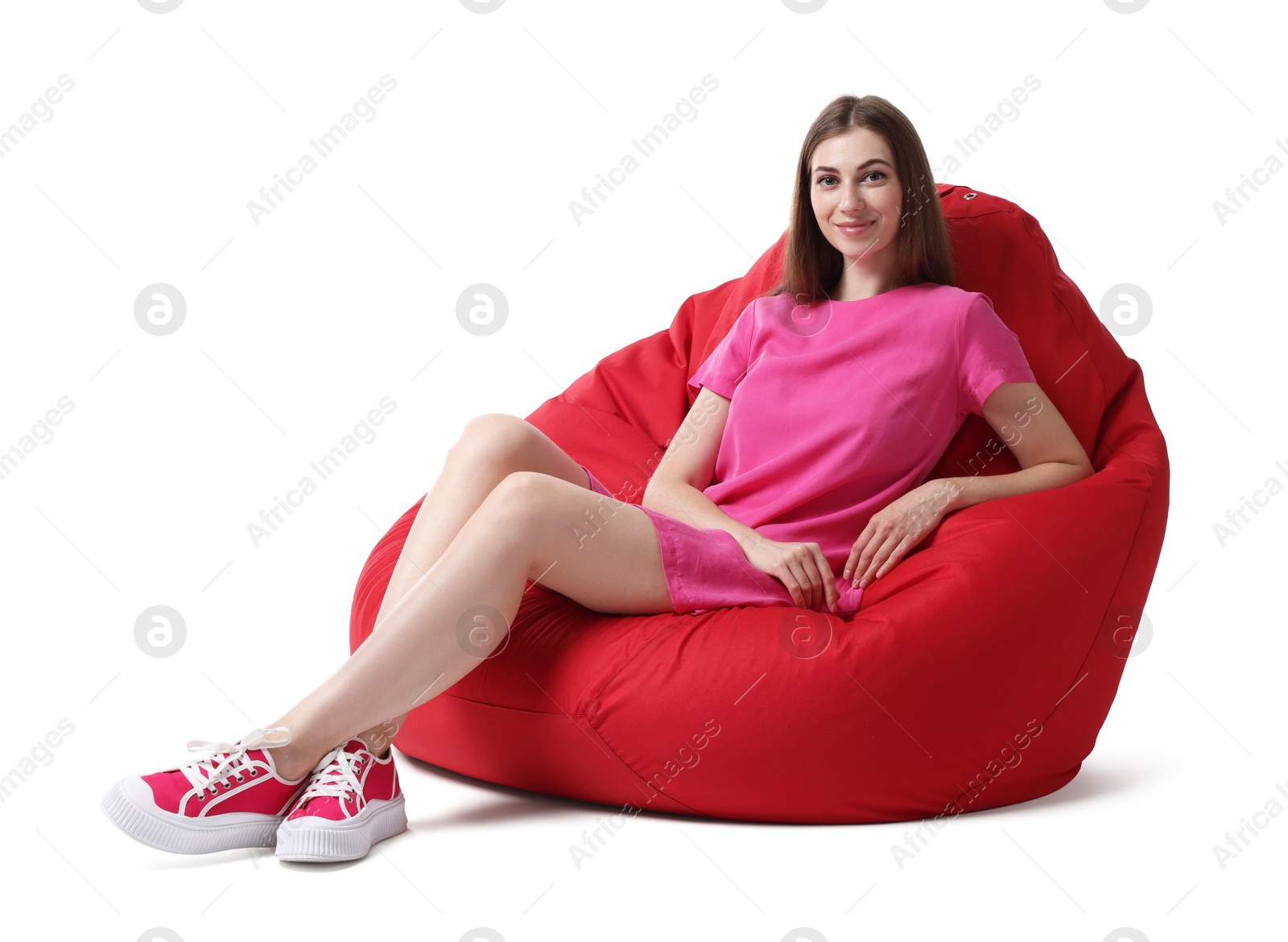 Photo of Beautiful young woman sitting on red bean bag chair against white background