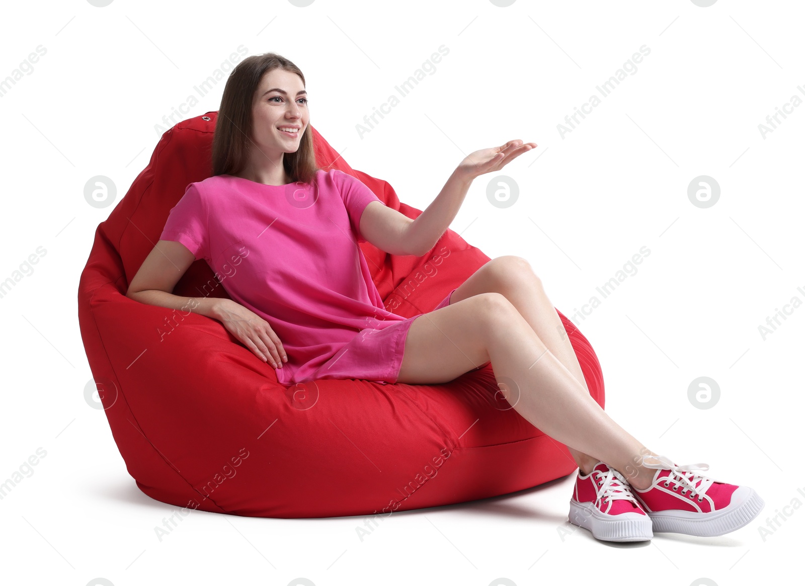 Photo of Smiling woman sitting on red bean bag chair against white background