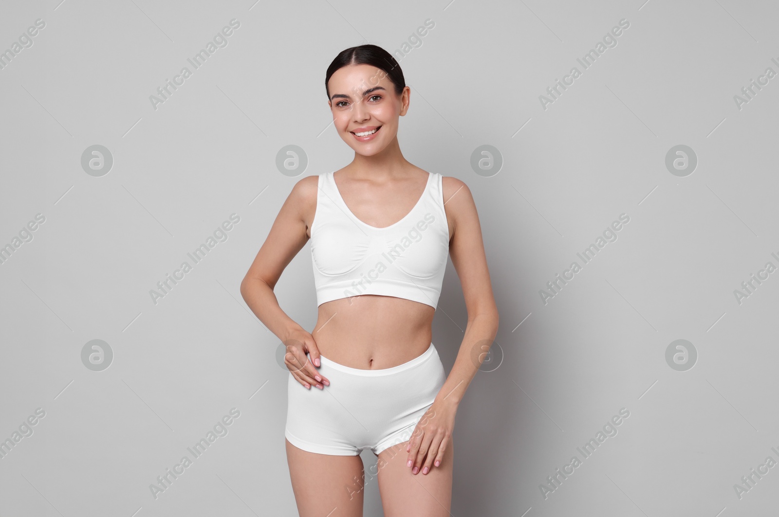 Photo of Diet and weight loss concept. Beautiful young woman with slim body against light grey background. Space for text