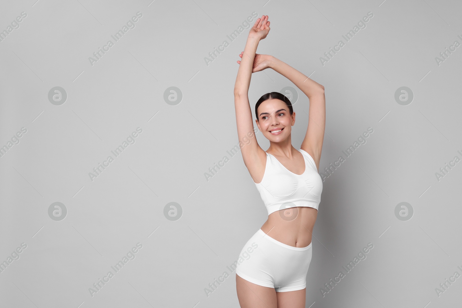 Photo of Diet and weight loss concept. Beautiful young woman with slim body against light grey background. Space for text