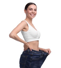 Photo of Diet and weight loss concept. Happy young woman in big jeans showing her slim body on white background