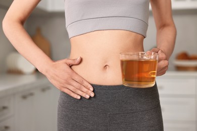 Photo of Weight loss concept. Woman with cup of diet tea indoors, closeup