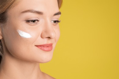 Beautiful woman with cream on her face against olive background, closeup. Space for text