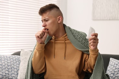 Cold symptom. Young man coughing at home