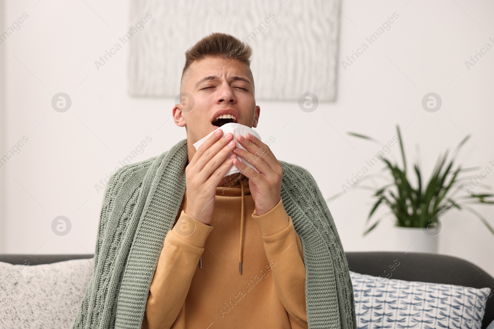 Photo of Cold symptom. Young man with runny nose at home