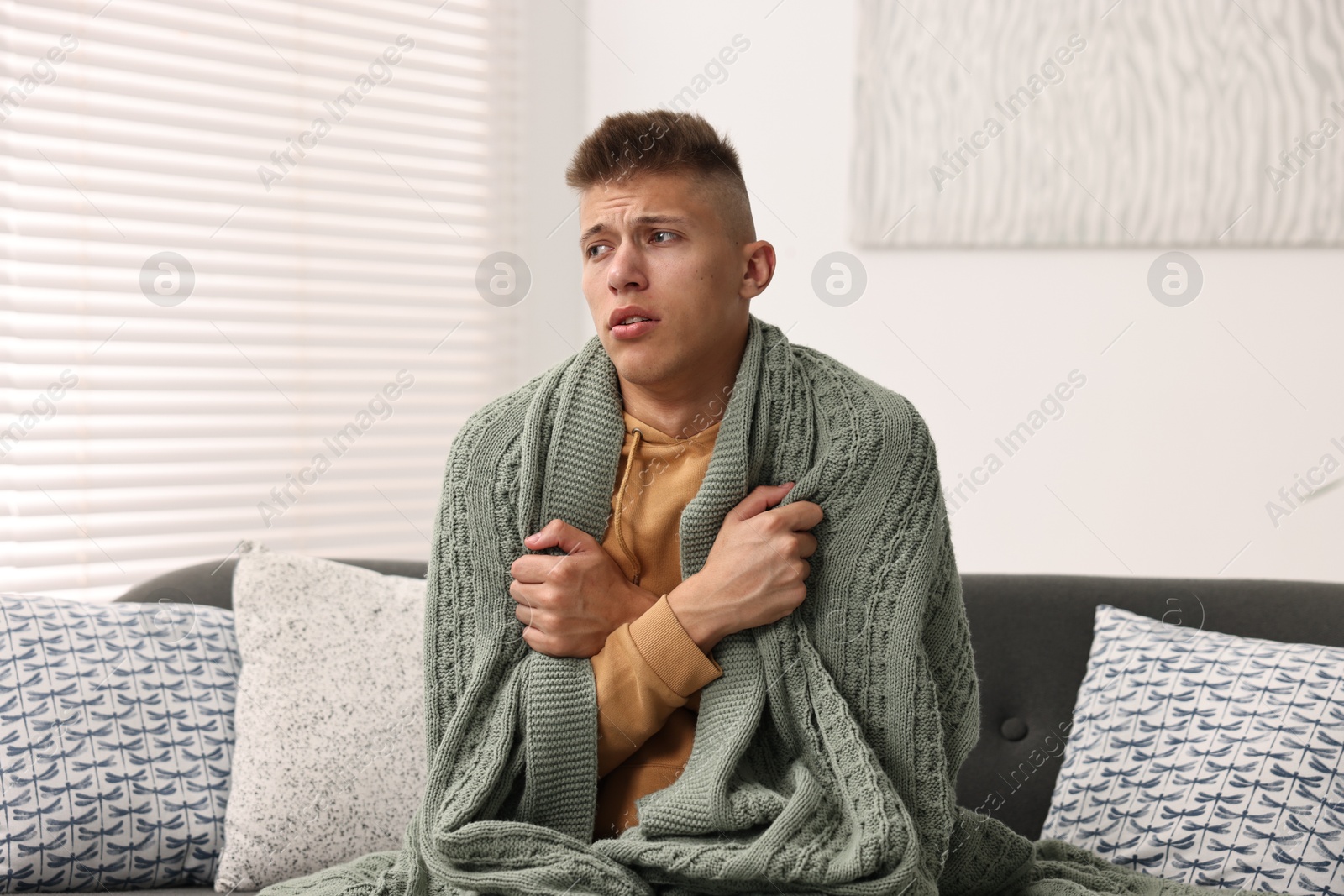 Photo of Cold symptom. Young man suffering from fever at home