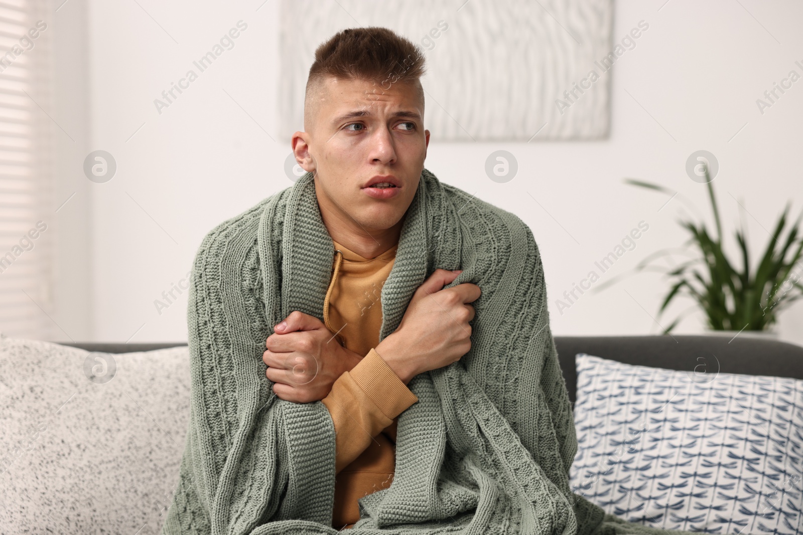 Photo of Cold symptom. Young man suffering from fever at home