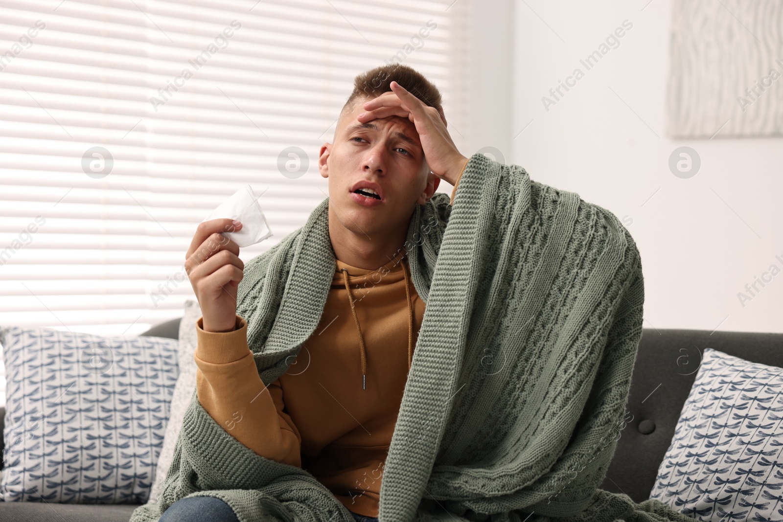 Photo of Cold symptom. Young man suffering from fever at home