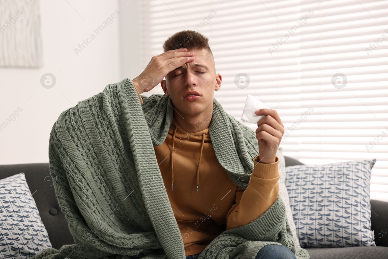 Photo of Cold symptom. Young man suffering from fever at home