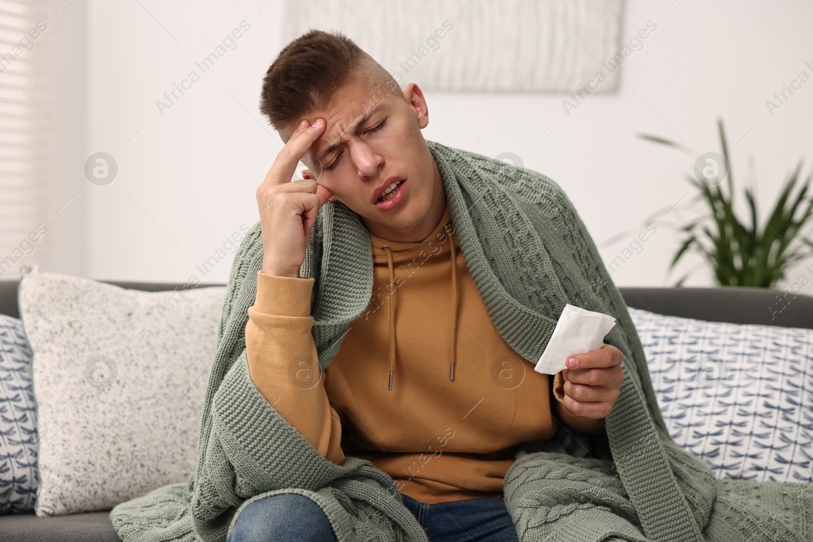 Photo of Cold symptom. Young man suffering from fever at home