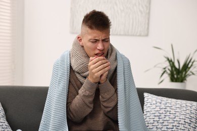 Photo of Cold symptom. Young man coughing at home