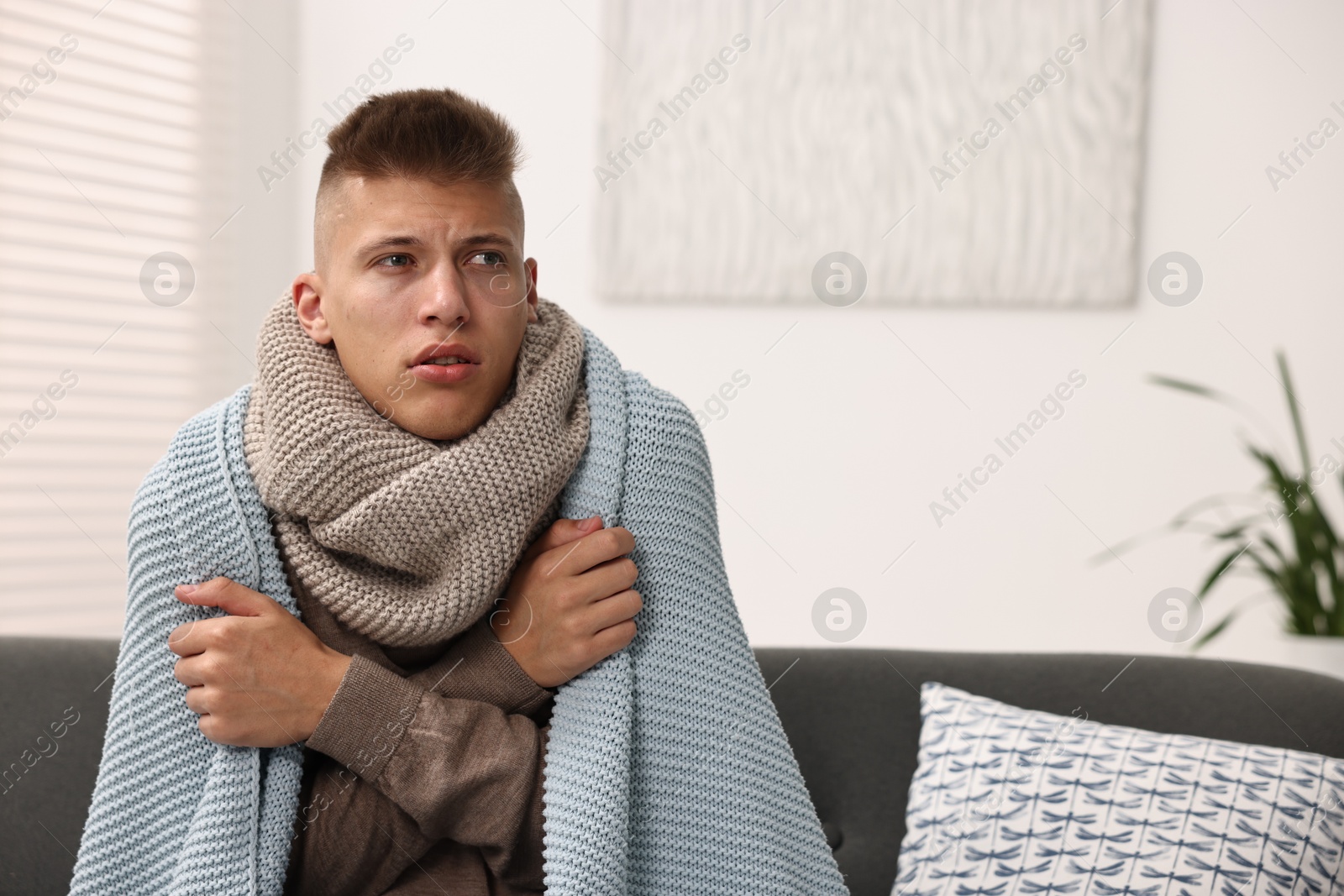 Photo of Cold symptom. Young man suffering from fever at home