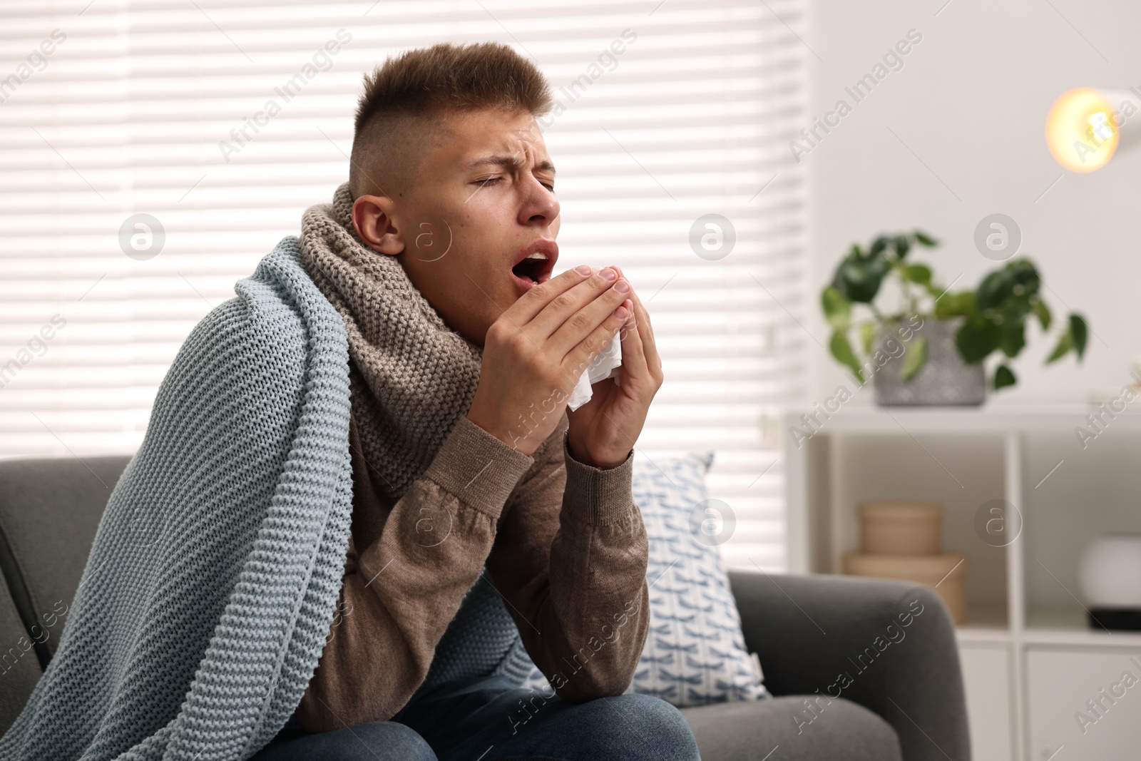 Photo of Cold symptom. Young man coughing at home