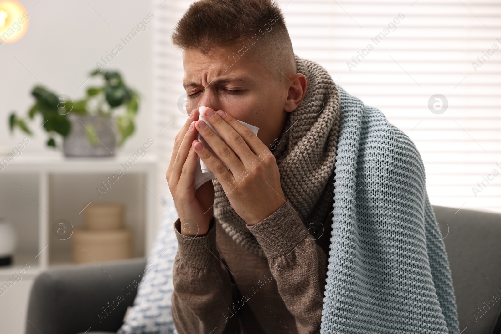 Photo of Cold symptom. Young man with runny nose at home