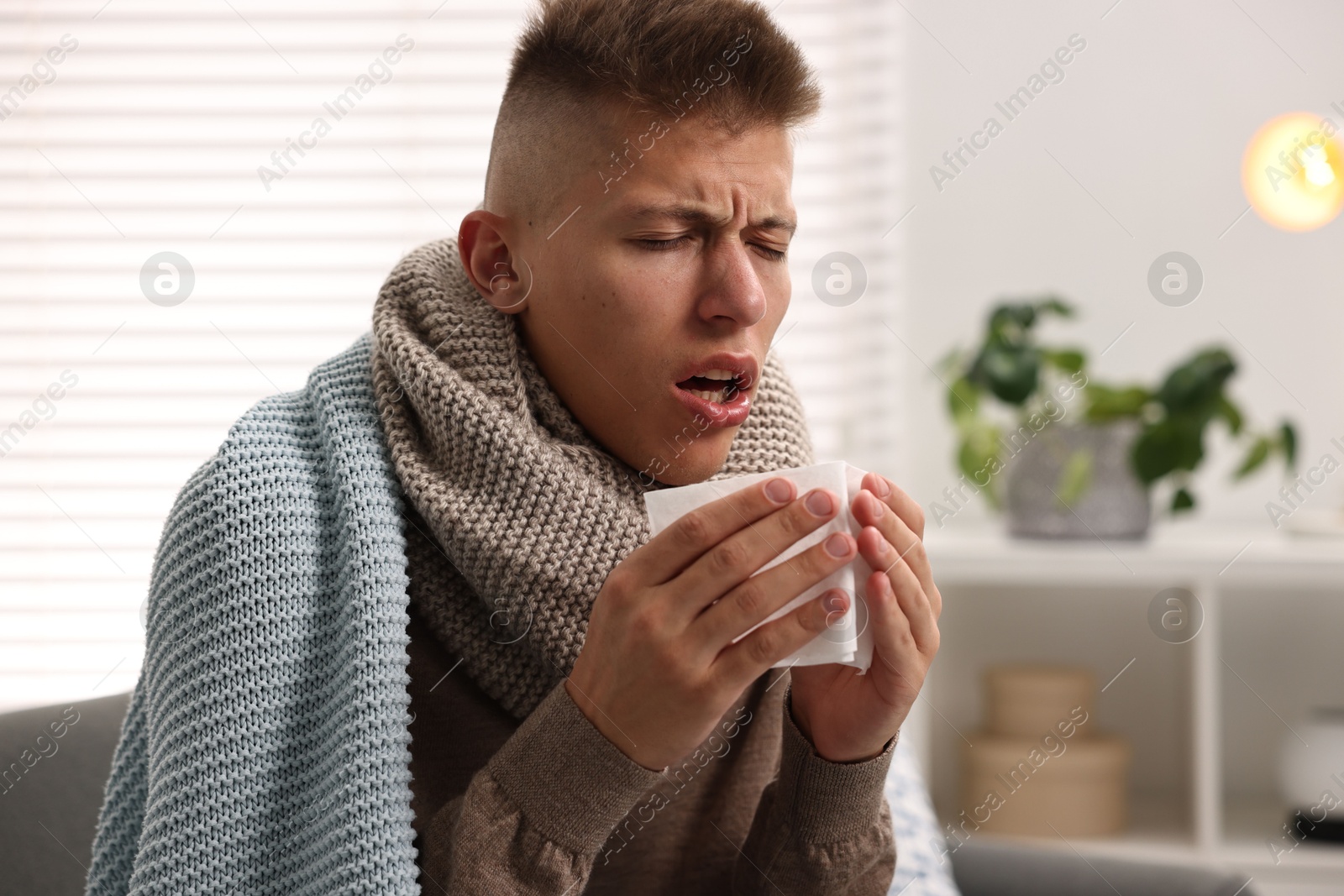 Photo of Cold symptom. Young man coughing at home