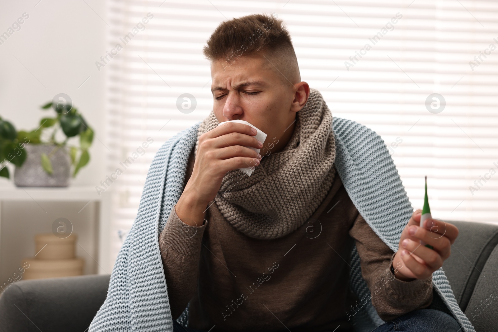 Photo of Cold symptom. Young man suffering from fever at home