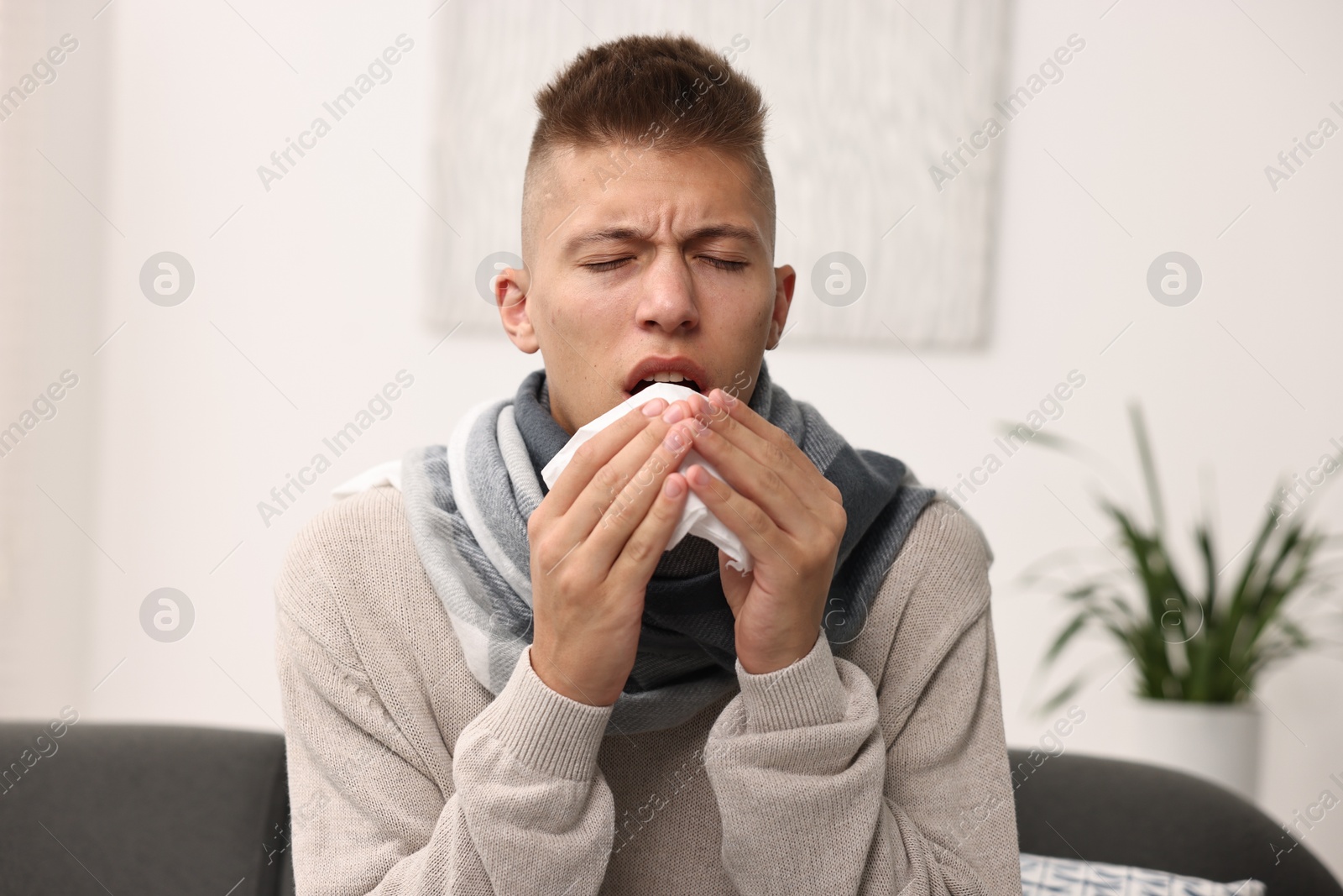 Photo of Cold symptom. Young man with runny nose at home