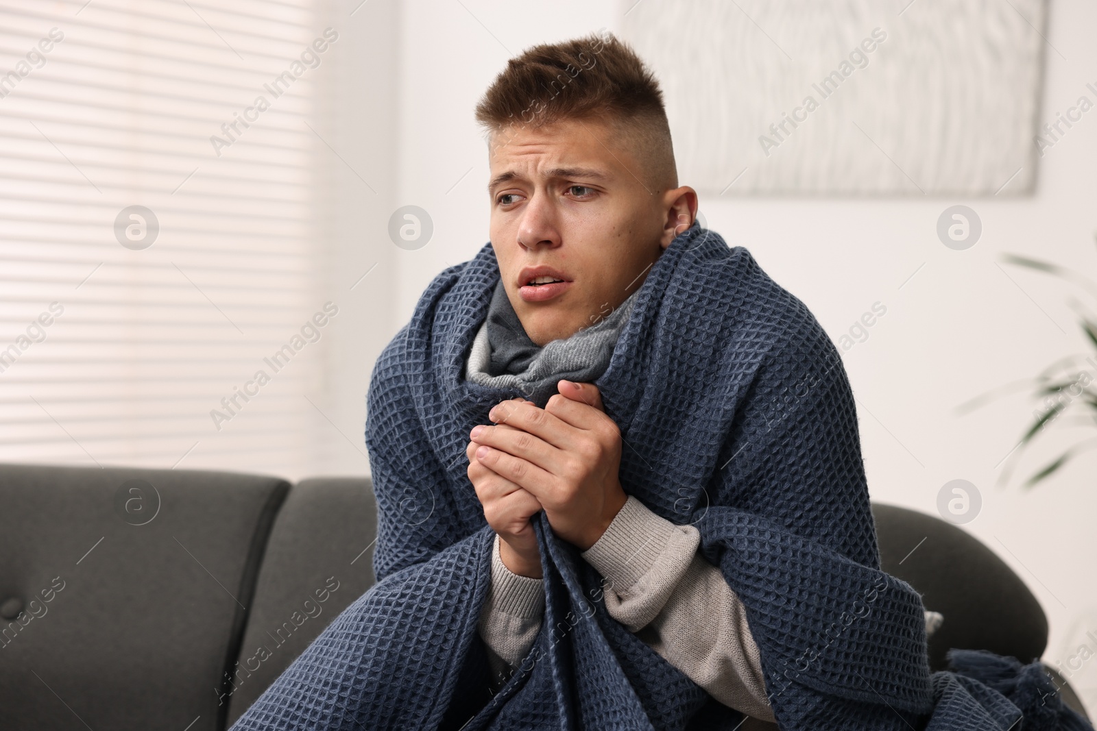 Photo of Cold symptom. Young man suffering from fever at home