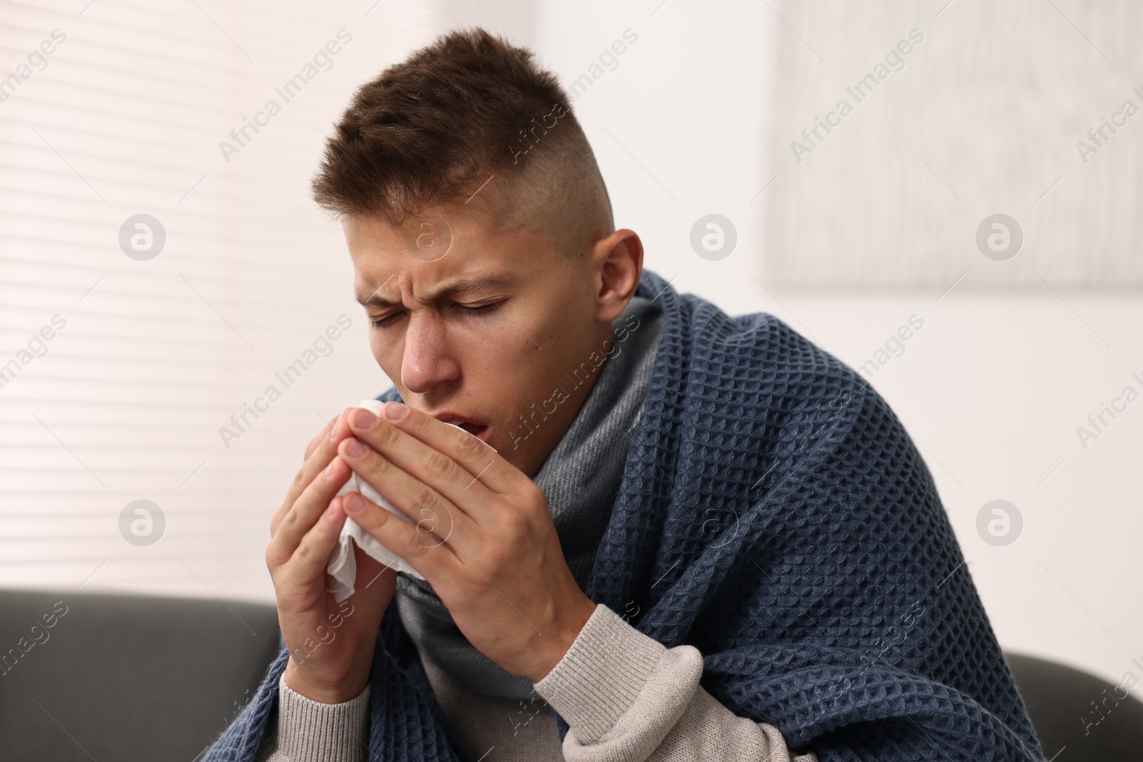 Photo of Cold symptom. Young man with runny nose at home