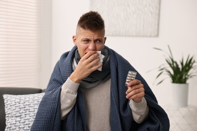 Photo of Cold symptom. Young man with runny nose at home