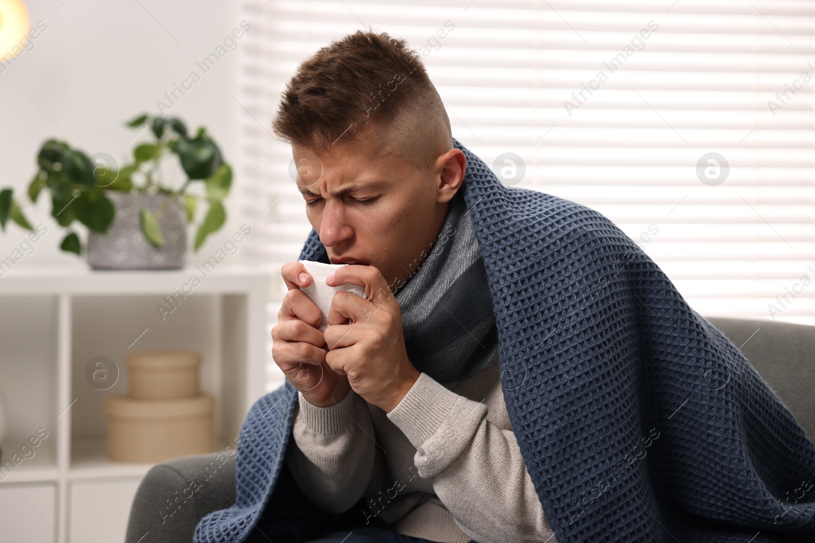 Photo of Cold symptom. Young man with runny nose at home