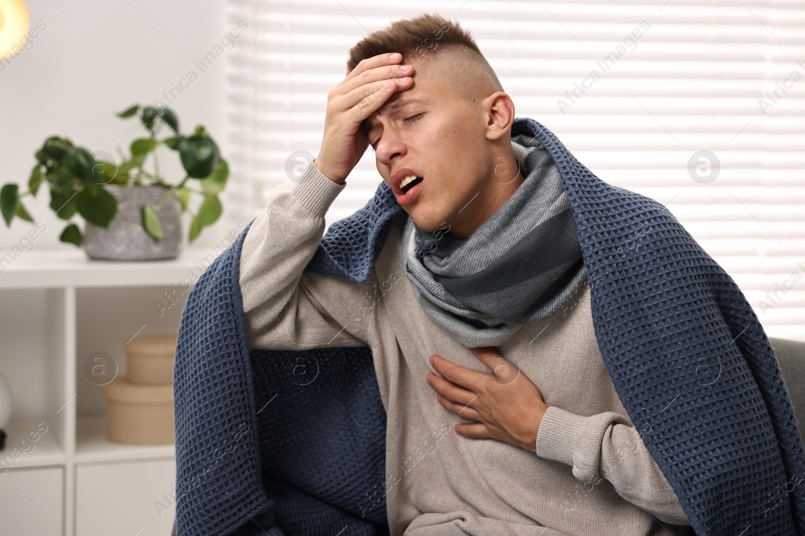 Photo of Cold symptom. Young man suffering from fever at home