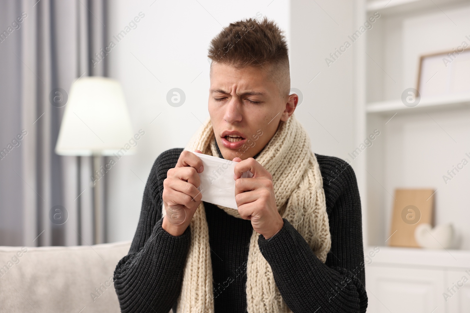 Photo of Cold symptom. Young man with runny nose at home