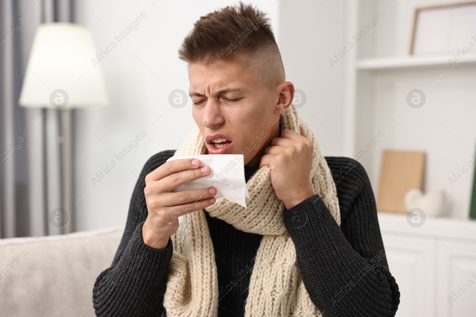 Photo of Cold symptom. Young man with runny nose at home