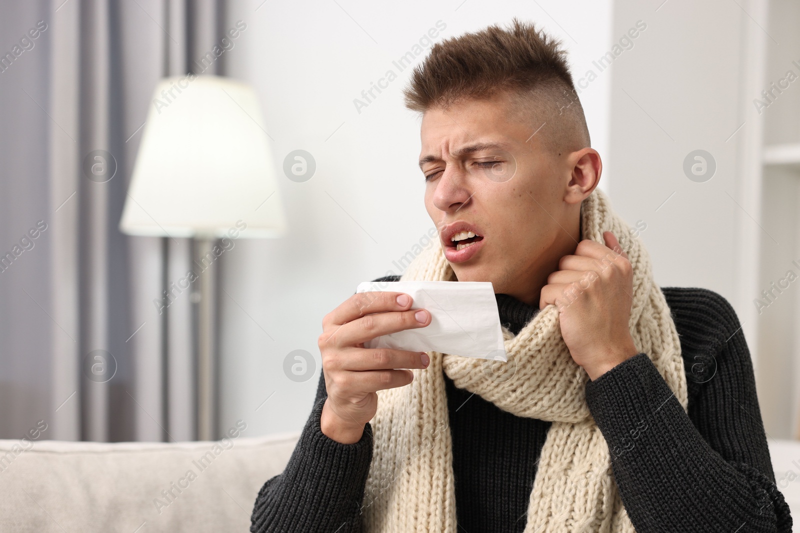 Photo of Cold symptom. Young man coughing at home