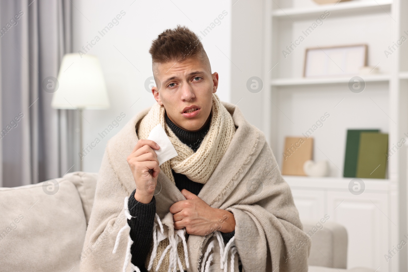 Photo of Cold symptom. Young man suffering from fever at home