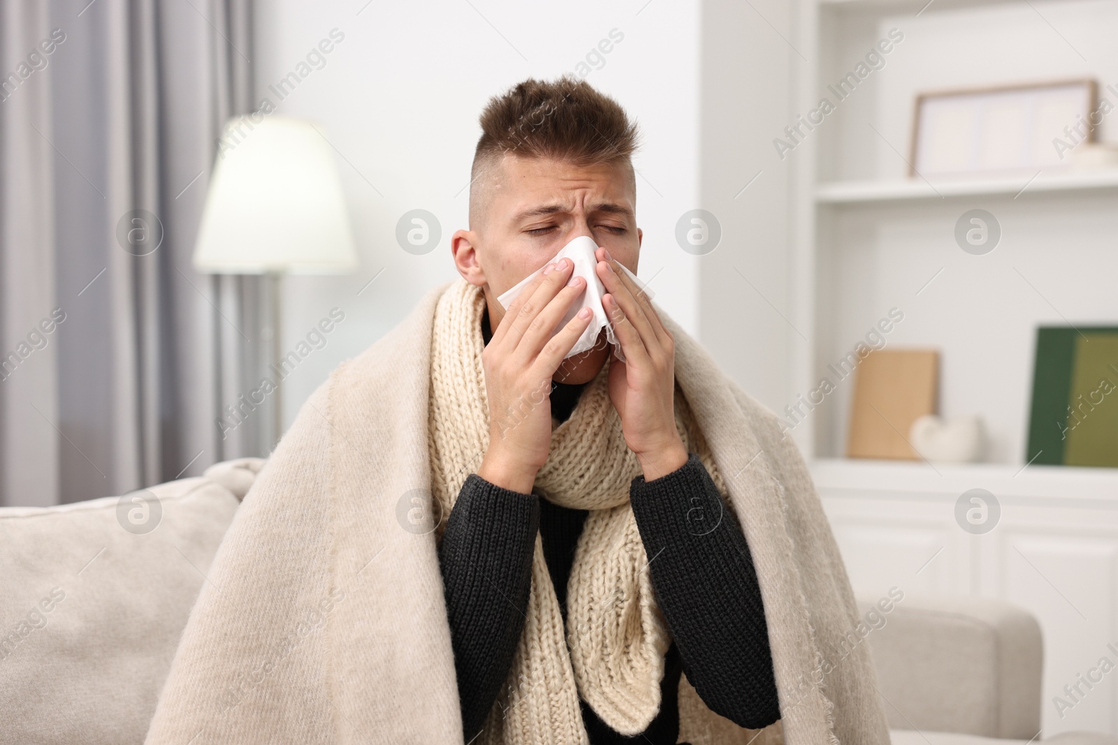 Photo of Cold symptom. Young man with runny nose at home