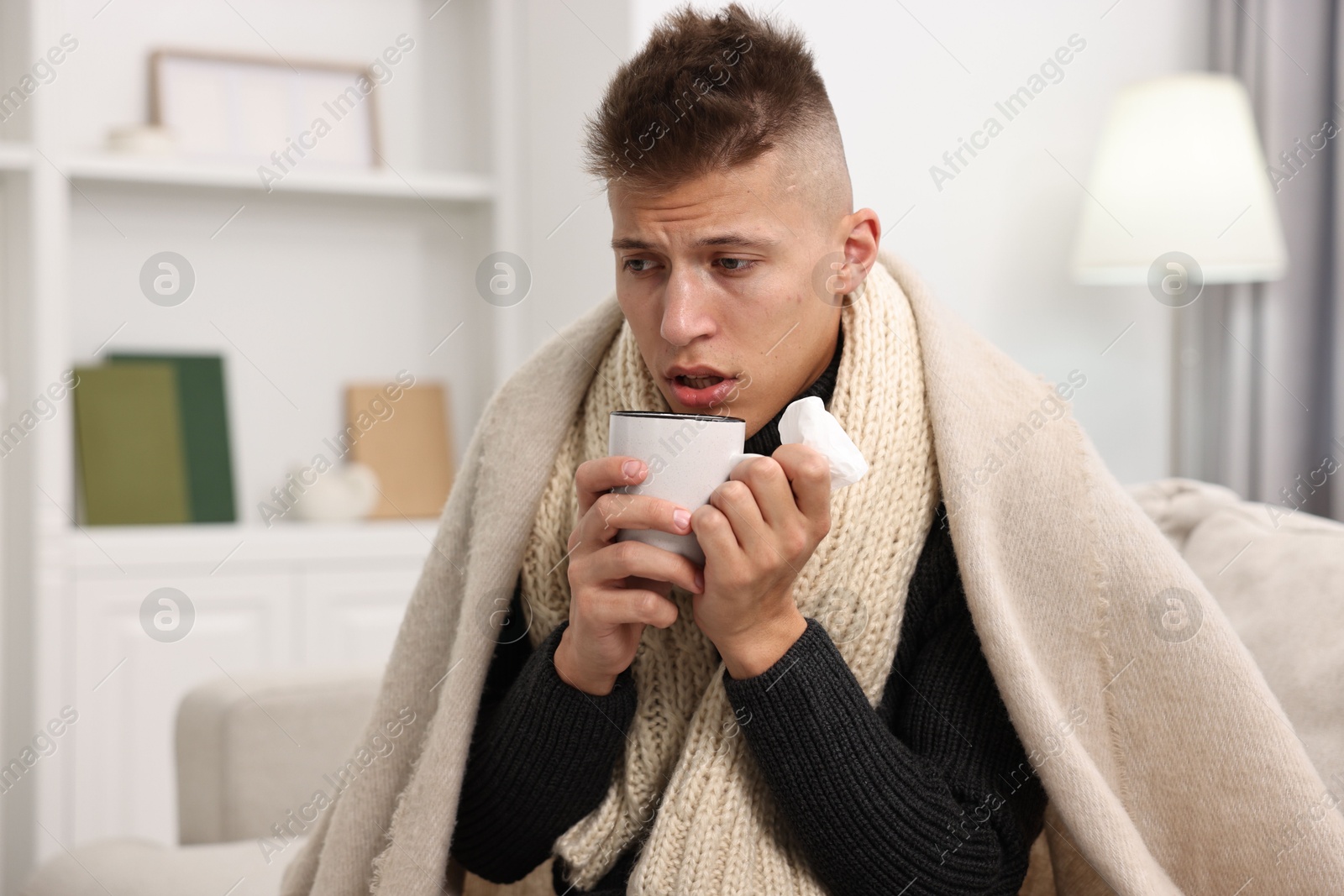 Photo of Cold symptom. Young man suffering from fever at home