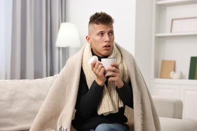 Photo of Cold symptom. Young man suffering from fever at home