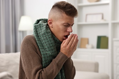 Photo of Cold symptom. Young man coughing at home