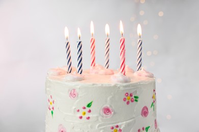 Photo of Tasty Birthday cake with burning candles against light grey background, closeup