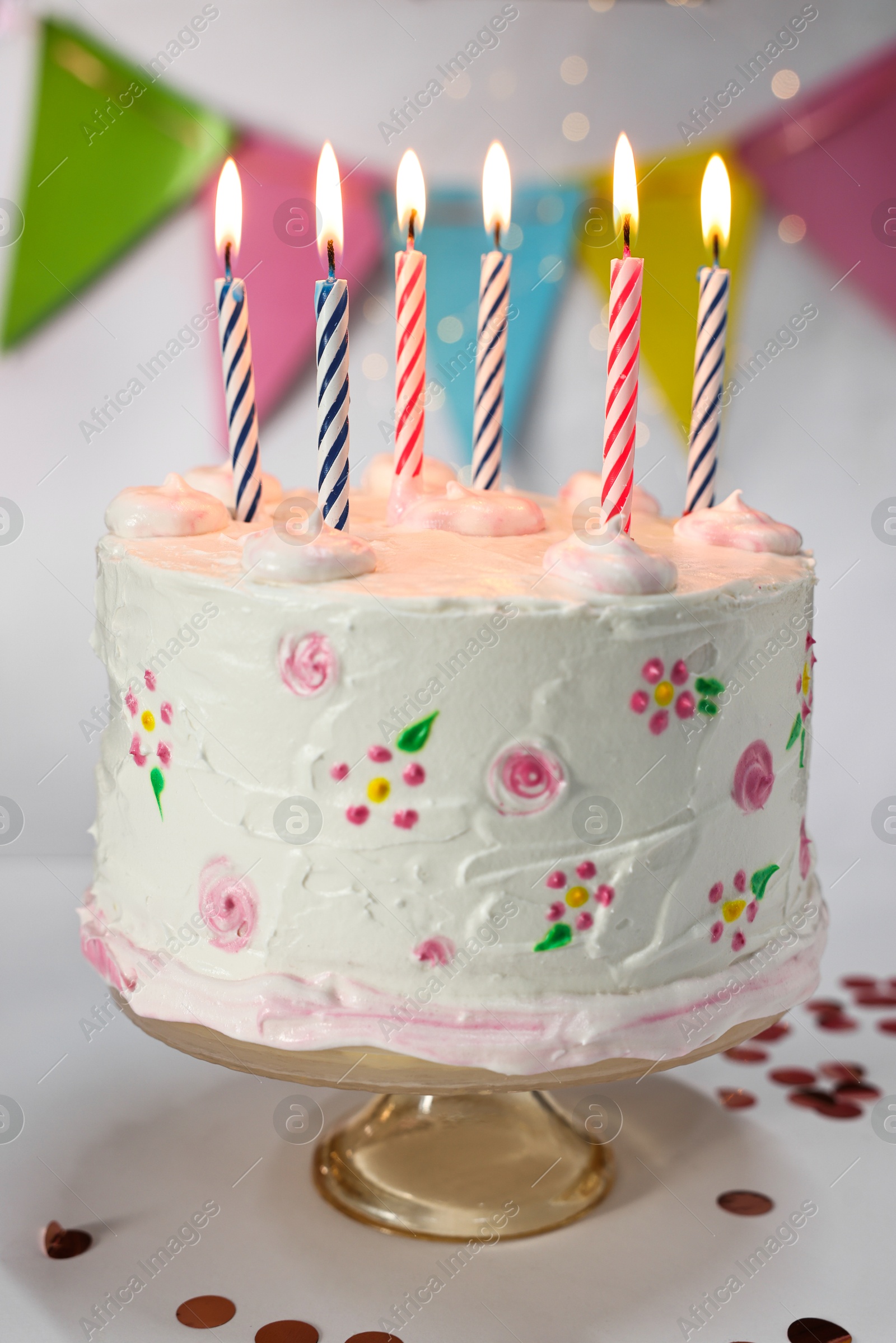 Photo of Tasty Birthday cake with burning candles and confetti on white table