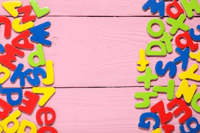 Learning alphabet. Magnetic letters on pink wooden background, flat lay. Space for text