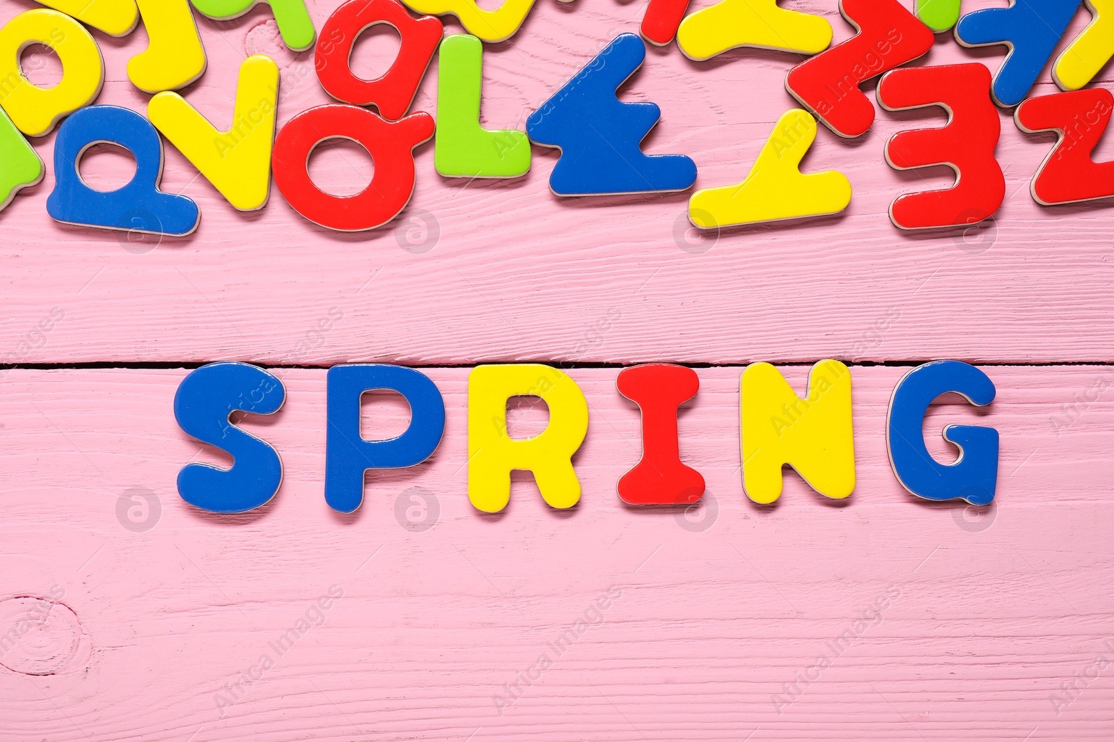 Photo of Word Spring made of magnetic letters on pink wooden background, flat lay. Learning alphabet